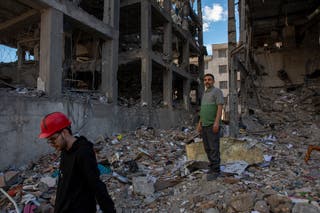 People walk among buildings destroyed in a joint attack by Israel and the United States on April 6, 2026, in Tehran, Iran